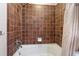 Clean bathroom with a tub and shower combination and brown tile at 1541 Truscott Ct, Mount Dora, FL 32757