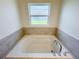 Bathroom features a large soaking tub with tile surround and chrome fixtures at 2181 Emma Ln, Lake Wales, FL 33859