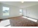 Bright bedroom with carpet flooring, two windows, and a white door at 2181 Emma Ln, Lake Wales, FL 33859