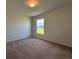 Cozy bedroom with neutral carpet, a window for natural light, and white trim at 2181 Emma Ln, Lake Wales, FL 33859