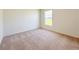 This bedroom features neutral carpet, a window providing natural light, and ample space at 2181 Emma Ln, Lake Wales, FL 33859