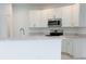 Bright kitchen featuring white cabinets, stainless steel appliances, and stone countertops at 2181 Emma Ln, Lake Wales, FL 33859