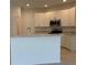 Modern kitchen boasts white cabinets, breakfast bar, stainless steel appliances, and plenty of counter space at 2181 Emma Ln, Lake Wales, FL 33859