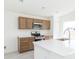 Modern kitchen features stainless steel appliances, wood cabinets, and bright countertops at 2203 Carson Loop, Lake Wales, FL 33859