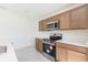 Modern kitchen features stainless steel appliances, wood cabinets, and bright countertops at 2203 Carson Loop, Lake Wales, FL 33859