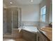 Bright bathroom featuring a glass shower, soaking tub, and spacious vanity with neutral color palette at 416 Central Ave, Frostproof, FL 33843