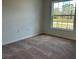 Cozy bedroom featuring neutral carpet and a large window for natural light at 416 Central Ave, Frostproof, FL 33843