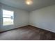 An empty bedroom has carpet floors and a window looking outside at 418 Central Ave, Frostproof, FL 33843