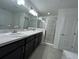 Elegant main bathroom with a double vanity, walk-in shower with marble accents, and tile flooring at 418 Central Ave, Frostproof, FL 33843