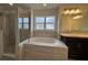 Luxurious bathroom featuring a soaking tub, glass-enclosed shower, and elegant vanity with ample lighting at 422 Central Ave, Frostproof, FL 33843