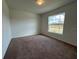 Cozy bedroom featuring a large window, neutral carpet, and freshly painted walls at 422 Central Ave, Frostproof, FL 33843