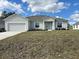 Charming single-story home with light-colored exterior, attached garage, and landscaped front yard on a sunny day at 422 Central Ave, Frostproof, FL 33843