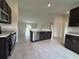 Spacious kitchen with stainless steel appliances, dark cabinets, and a large island overlooking the living area at 422 Central Ave, Frostproof, FL 33843