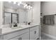 Modern bathroom with double sinks, a large mirror, and a glass-enclosed shower at 7838 Sloewood Dr, Leesburg, FL 34748