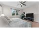 Bright bedroom featuring a comfortable bed, a workspace, and a large TV at 7838 Sloewood Dr, Leesburg, FL 34748