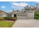 Single-story house featuring a two-car garage and neatly manicured lawn at 7838 Sloewood Dr, Leesburg, FL 34748