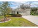 House exterior showcasing a two-car garage and well-maintained landscaping at 7838 Sloewood Dr, Leesburg, FL 34748