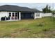 Well-maintained backyard with green lawn and enclosed patio, perfect for outdoor enjoyment at 837 Oaks Shores Rd, Leesburg, FL 34748
