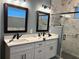 Bathroom featuring double sinks, modern fixtures, a glass-enclosed shower, and decorative tile on the wall at 837 Oaks Shores Rd, Leesburg, FL 34748