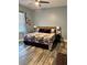 Bedroom featuring wood-look flooring, a ceiling fan, and a queen-sized bed with a floral patterned comforter at 837 Oaks Shores Rd, Leesburg, FL 34748