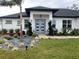 White house with gray door, landscaping, and paved driveway at 837 Oaks Shores Rd, Leesburg, FL 34748