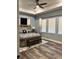 Spacious main bedroom with a tray ceiling, wood-look flooring, three large windows, and a decorative color palette at 837 Oaks Shores Rd, Leesburg, FL 34748