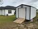 White storage shed with ramp access, providing extra storage space in backyard at 837 Oaks Shores Rd, Leesburg, FL 34748