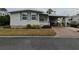 Single-wide manufactured home with covered carport and small front yard at 110 Dogwood Trl, Leesburg, FL 34748