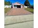 Brick driveway leading to a pink house garage at 1273 Tyler Lake Cir, Orlando, FL 32839