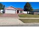 Front view of a pink house with a brick driveway and lawn at 1273 Tyler Lake Cir, Orlando, FL 32839