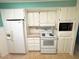 White kitchen with range, microwave and refrigerator at 188 Azalea Trl, Leesburg, FL 34748