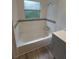 Clean bathroom with a tub and shower, new tile, and flooring at 253 N Blue Lake Ave, Deland, FL 32724