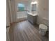 Updated bathroom features a gray vanity, new flooring, and a bathtub at 253 N Blue Lake Ave, Deland, FL 32724