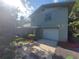 Green house with white garage door and landscaping at 253 N Blue Lake Ave, Deland, FL 32724