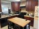 Kitchen featuring dark wood cabinets, black appliances, and a central island with seating for casual dining at 255 Sandlewood Trl # 4, Winter Park, FL 32789