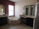 Bathroom with double sinks, corner bathtub, and separate shower at 2802 Quiet Water Trl, Kissimmee, FL 34744