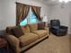 Living room with beige couch, recliner, and patterned curtains at 3376 Se 94Th St, Ocala, FL 34480