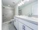 Bright bathroom features double vanity, white cabinets, and tiled walk-in shower at 3556 Elliot Pl, Bartow, FL 33830