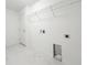 Clean, white laundry room with modern hookups, door, and shelving above at 3556 Elliot Pl, Bartow, FL 33830