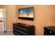 Bedroom with mounted TV and dresser at 4055 Beacon Ridge Way, Clermont, FL 34711