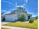 White house with a two-car garage and landscaped lawn at 4481 Reding Way, Lakeland, FL 33813