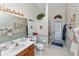 Well-lit bathroom featuring floral wallpaper, a vanity with a sink, a toilet, and glass door shower at 766 Bryson Loop, Lakeland, FL 33809