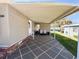 Inviting covered parking area with tiled flooring and space for seating and outdoor enjoyment at 100 Papaya Cv, Leesburg, FL 34748