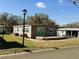 Charming single-story home featuring a covered porch and well-maintained lawn with mature trees at 100 Papaya Cv, Leesburg, FL 34748