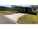 Charming single-story home featuring a covered porch and driveway with a well-maintained lawn at 100 Papaya Cv, Leesburg, FL 34748