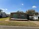 Charming single-story home featuring a covered porch and carport with a well-maintained lawn at 100 Papaya Cv, Leesburg, FL 34748