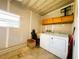 Unfinished laundry room area with washer, dryer, sink and storage cabinets at 100 Papaya Cv, Leesburg, FL 34748