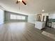Expansive living room flowing into a kitchen area with an island and stainless steel appliances at 100 Papaya Cv, Leesburg, FL 34748