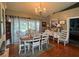 Formal dining room with elegant chandelier, traditional furnishings, and sliding glass doors to the outdoor pool area at 1315 Red Colt Ct, Astor, FL 32102