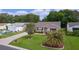Aerial view of a home with a well-manicured lawn, driveway, and mature landscaping at 1411 Juarez Pl, The Villages, FL 32159